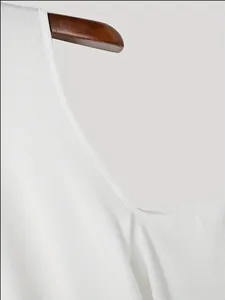 Primer plano del tejido de punto acanalado blanco y el diseño de hombros caídos de un top.