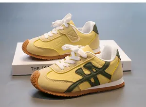 Vista lateral de zapatillas retro amarillas y beige para niños con detalles verdes