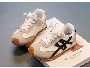 Detalle de zapatillas retro para niños en cuero blanco y ante con suela de goma