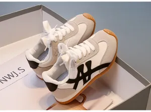 Zapatillas retro para niños en tela beige y negra con suela de goma, ideales para jugar