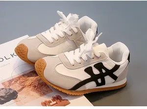 Vista lateral detallada de zapatillas retro para niños en color crema y gris suave
