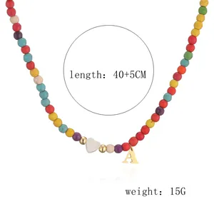 Detailed view of colorful bead necklace with heart pendant and golden letter A charm
