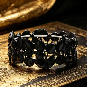 Macro view of vintage wide black crystal bracelet with leaf design on a gold book