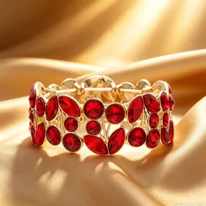 Detailed close-up view of a vintage gold-toned bracelet with deep red leaf-shaped crystals