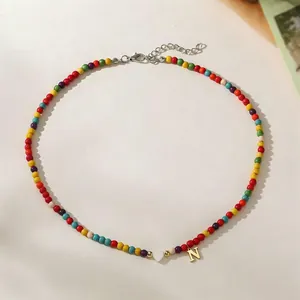 Detailed view of colorful beads with heart charm and gold letter N pendant.