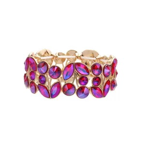 Detailed view of vintage gold cuff bracelet with red and purple crystals in leaf design