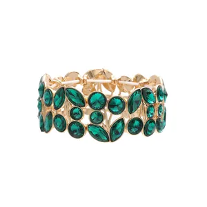 Detailed view of vintage wide golden bracelet with faceted green leaf crystals