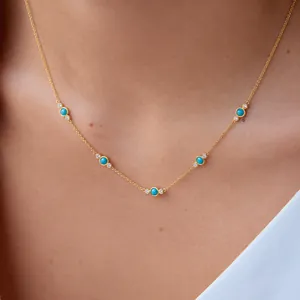 Primer plano de un elegante collar de acero inoxidable con turquesas y circonitas al cuello