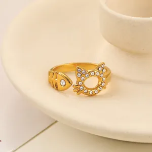 Dettaglio dell'anello aperto in acciaio dorato con gatto e lisca di pesce con strass