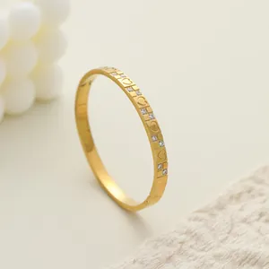Detalle de brazalete de acero inoxidable dorado con corazones y pedrería incrustada
