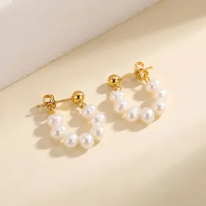 Detalle de los pendientes en forma de C dorados con perlas naturales de agua dulce