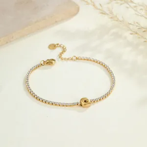 Detailansicht eines goldfarbenen Edelstahl-Tennisarmbands mit einem G-Buchstaben