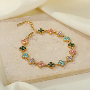 Detailansicht eines goldfarbenen Edelstahlarmbands mit bunten Strasssteinen als Blumen