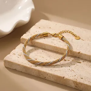 Detaillierte Nahaufnahme des gold- und silberfarbenen geflochtenen Netzarmbands Damen