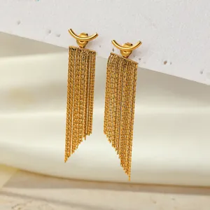 Detail view showing the fine texture of gold snake chain tassels on arc drop earrings.
