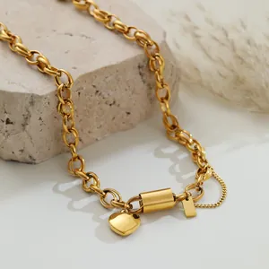 Detailed macro view of a chunky gold stainless steel heart pendant necklace on a stone