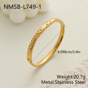 Primer plano detallado de pulsera de acero inoxidable dorado con grabados de estrellas y sol.