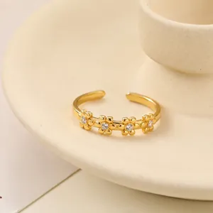 Vista dettagliata di un elegante anello a fiore dorato con accenti di cristallo
