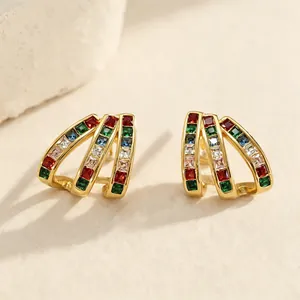 Vue détaillée de boucles d'oreilles dorées avec des zircons arc-en-ciel éclatants.