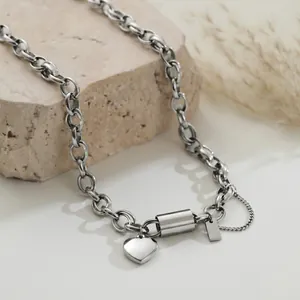 Close-up detail of stainless steel chunky chain necklace featuring a heart pendant