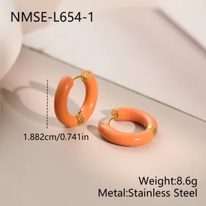 Close-up detail of vibrant orange enamel C-shaped hoop earrings made of stainless steel