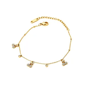 Détail d'un bracelet cerise en acier inoxydable doré avec des accents de cristal