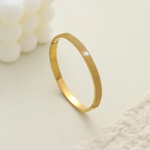 Vista detallada de brazalete de acero dorado con incrustación de nácar y textura