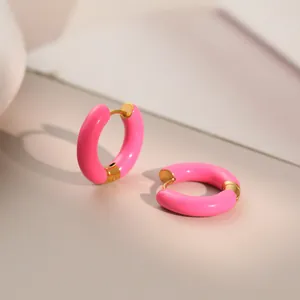 Detail view of vibrant pink enamel hoop earrings with gold-plated stainless steel accents.