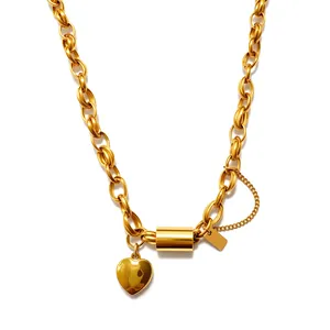 Detailed view of gold-colored chunky chain necklace with heart pendant and square tag.