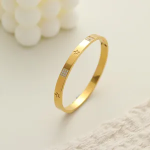 Elegante primer plano de un brazalete de acero inoxidable dorado con estrellas y piedras pavé