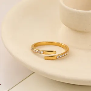Primo piano dettagliato di anello aperto in acciaio inossidabile dorato con strass.