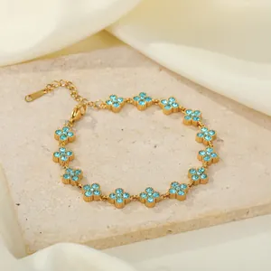 Nahaufnahme eines goldenen Edelstahlarmbands mit blauen Strass-Blumenclustern