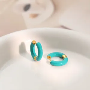 Close-up of vibrant teal enamel C-shaped hoop earrings with gold-plated stainless steel details.