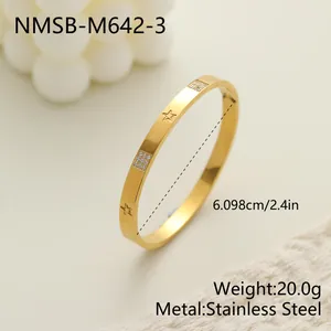 Detalle de brazalete de acero inoxidable dorado con grabado de estrella y pavé.