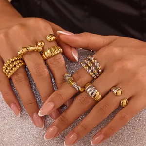 Detalle de anillos gruesos bicolor de acero inoxidable con motivos de bambú y cuentas
