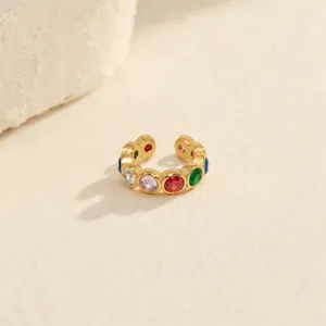 Bague d'oreille arc-en-ciel en acier doré et zircone sur un fond texturé élégant