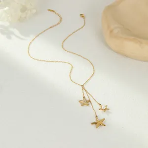 Detalle elegante del collar de borlas con estrella de mar dorada con cristales y perla