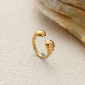 Primer plano de un anillo abierto de acero inoxidable dorado con puntas acanaladas