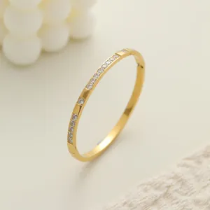 Elegante detalle lateral de brazalete de acero chapado en oro con cristales brillantes