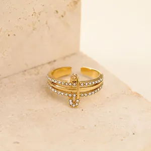 Dettaglio di un anello a spilla da balia dorato con strass bianchi scintillanti
