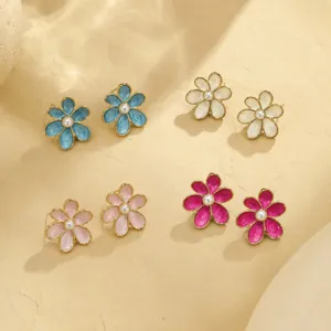 Vue macro détaillée de divers boucles d'oreilles fleurs en émail coloré avec des perles.