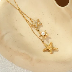 Detalle del collar con borlas de estrella de mar dorada con perla y cristales.