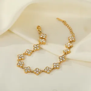 Detaillierte Makroansicht eines goldenen Edelstahl-Blumenarmbands mit weißen Kristallen