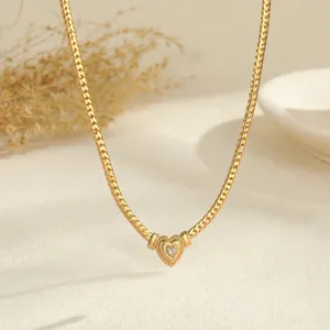 Detailopname van een vergulde hartjesketting met een schitterende centrale steen