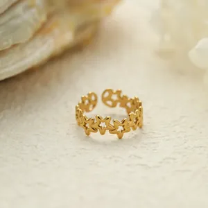 Primer plano detallado de un anillo abierto de acero inoxidable dorado con estrellas.