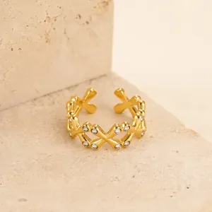 Dettaglio anello incrociato in acciaio inossidabile dorato con pietre di zircone - Chic