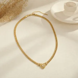 Gedetailleerd zicht op een vergulde Cubaanse ketting met een hartvormige kristallen hanger