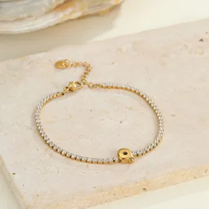Detailansicht eines goldenen Edelstahl-Tennisarmband mit Buchstaben-Q-Anhänger