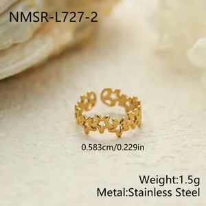 Primer plano de un anillo de acero inoxidable dorado con un diseño decorativo de estrellas.