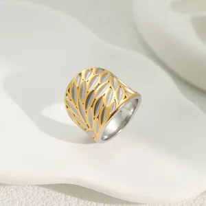 Detailed view of two-tone stainless steel ring with elegant hollow leaf design.